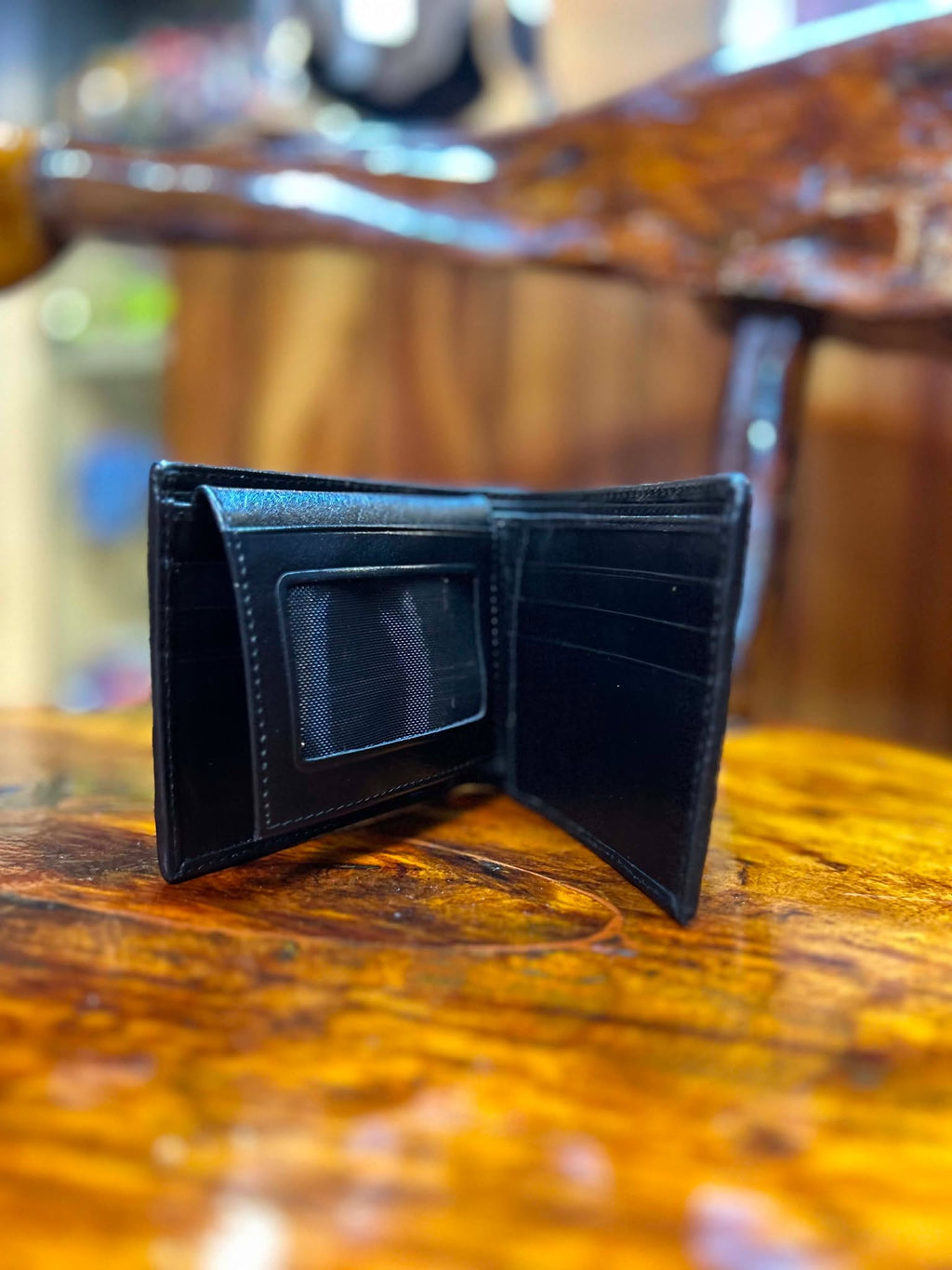 Black crocodile wallet open, showing ID window